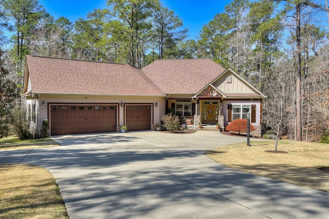 craftsman-style home featuring concrete driveway, a garage, stone siding, and a shingled roof