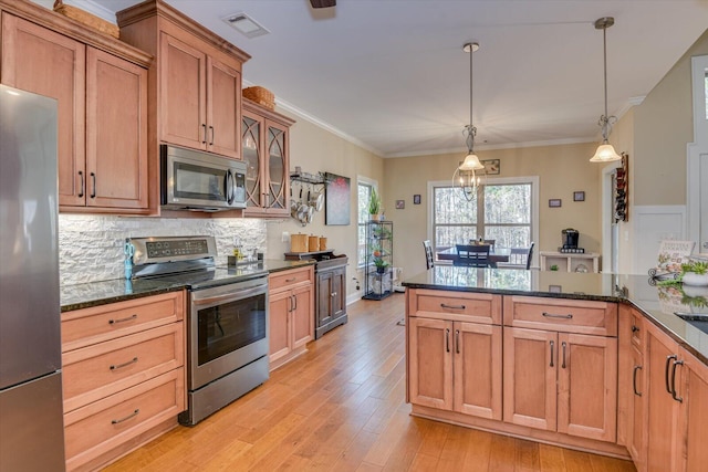 kitchen with stainless steel appliances, light wood-style floors, visible vents, and crown molding