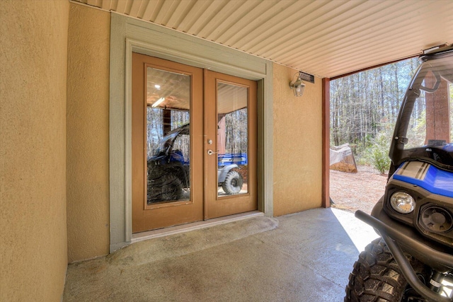 property entrance featuring stucco siding and french doors