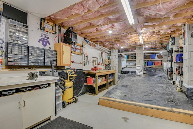 miscellaneous room featuring a workshop area and concrete floors