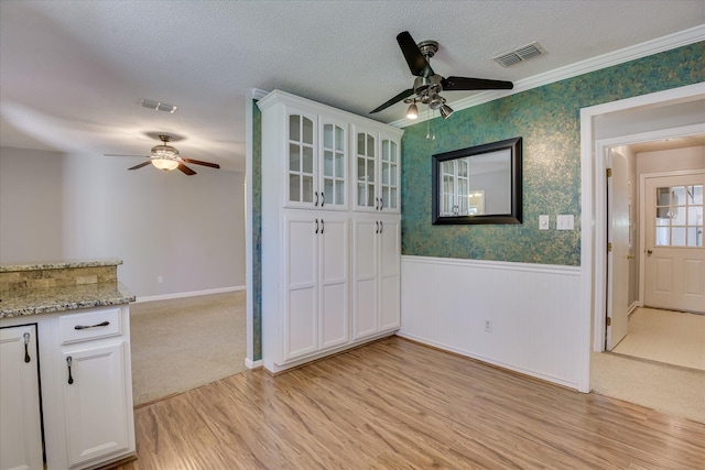 307 Candlewood Dr, Martinez, GA 30907 - unfurnished dining area featuring a ceiling fan, a wainscoted wall, light wood-type flooring, a textured ceiling, and wallpapered walls