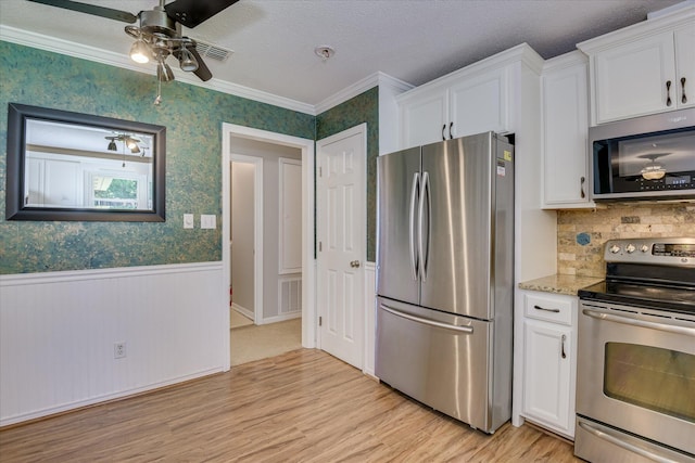 307 Candlewood Dr, Martinez, GA 30907 - kitchen with stainless steel appliances, light wood finished floors, white cabinetry, a wainscoted wall, and ornamental molding