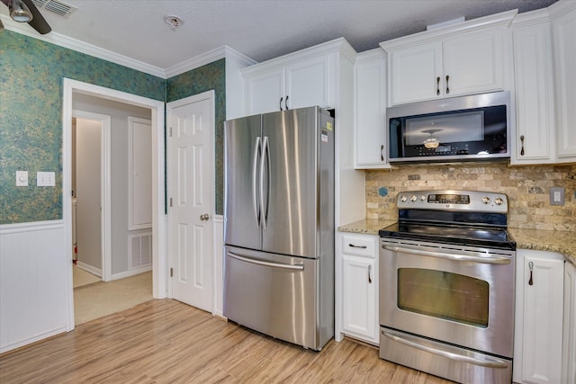 307 Candlewood Dr, Martinez, GA 30907 - kitchen with stainless steel appliances, white cabinetry, light wood-style flooring, light stone countertops, and ornamental molding