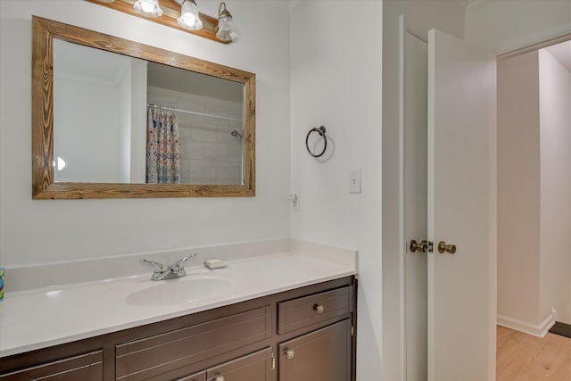 bathroom with vanity, wood finished floors, curtained shower, and baseboards