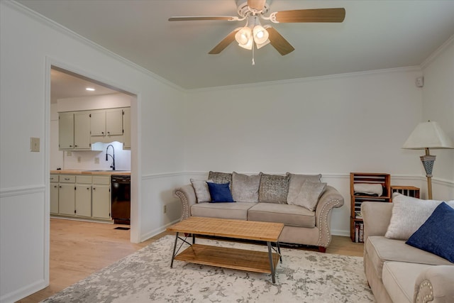 living room with crown molding, light wood-type flooring, and a ceiling fan