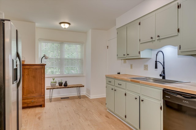 kitchen with dishwasher, stainless steel fridge, a sink, light wood finished floors, and baseboards