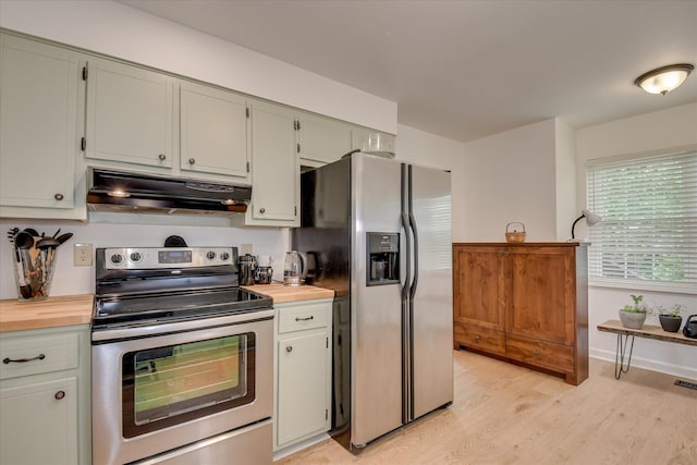 kitchen featuring appliances with stainless steel finishes, range hood, light wood finished floors, and baseboards