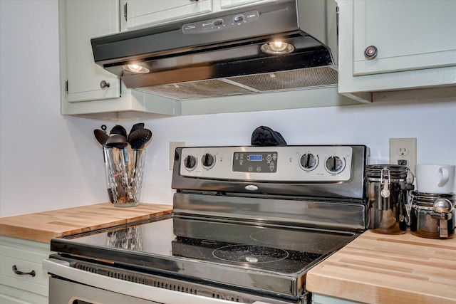 kitchen with stainless steel range with electric cooktop, wood counters, ventilation hood, and white cabinets
