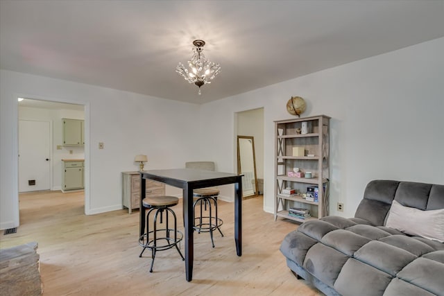 dining area with a chandelier, light wood-style flooring, and baseboards