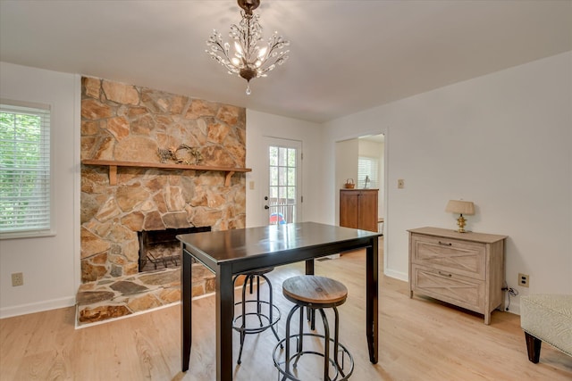 kitchen with light wood finished floors, healthy amount of natural light, a fireplace, and baseboards