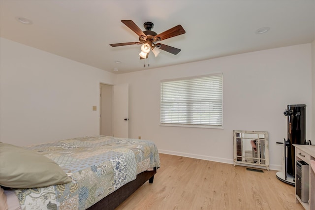 bedroom featuring light wood-style flooring, baseboards, and ceiling fan