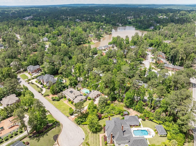 aerial view of property's location with a nearby body of water, a forest, and nearby suburban area