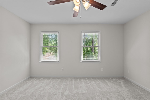carpeted empty room featuring baseboards and ceiling fan