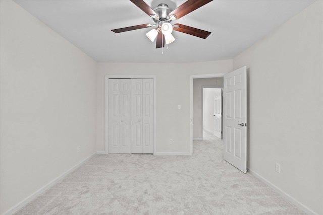 unfurnished bedroom with light colored carpet, a closet, baseboards, and ceiling fan