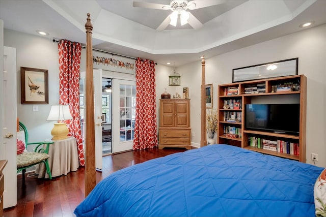 bedroom featuring hardwood / wood-style flooring, ceiling fan, a tray ceiling, recessed lighting, and access to exterior