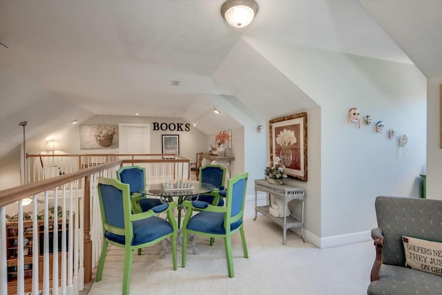 carpeted dining space featuring lofted ceiling and baseboards