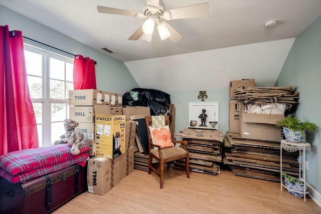 bedroom with light wood-type flooring, lofted ceiling, visible vents, and a ceiling fan