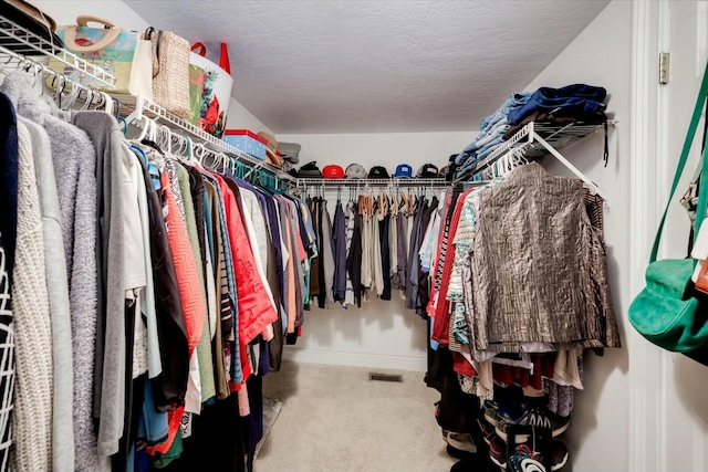 walk in closet featuring carpet flooring and visible vents