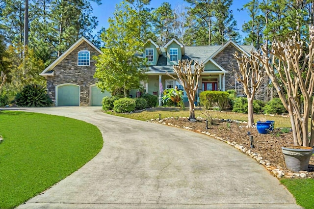 view of front of home with concrete driveway, a front yard, covered porch, a garage, and stone siding