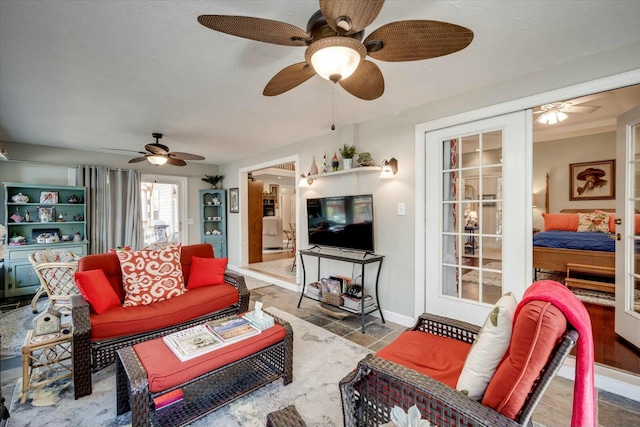 living room with a ceiling fan and baseboards