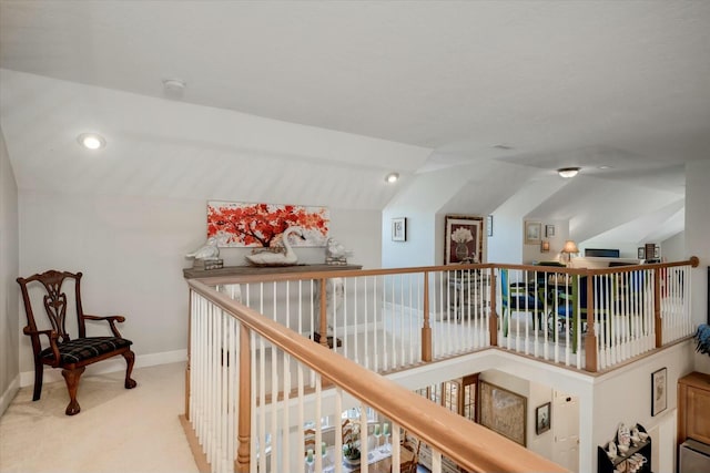 hallway featuring lofted ceiling, carpet flooring, an upstairs landing, and baseboards