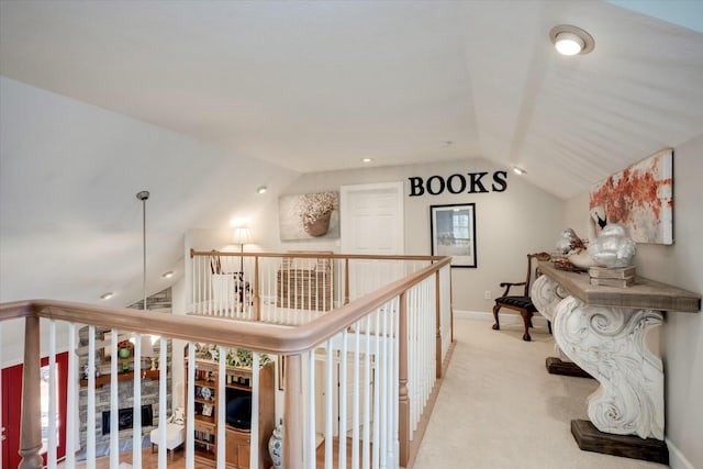 hallway featuring an upstairs landing, baseboards, carpet, and lofted ceiling