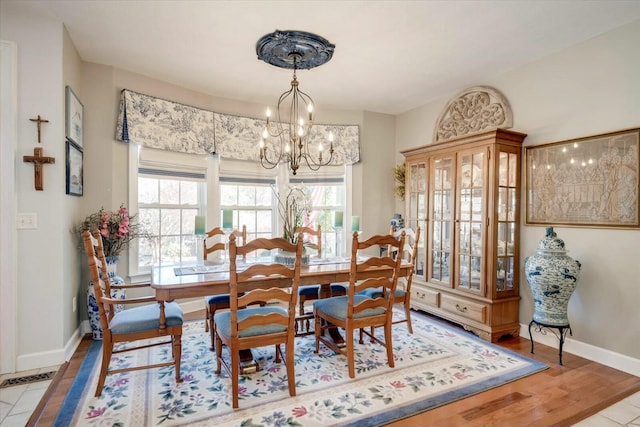 dining space with visible vents, baseboards, a notable chandelier, and wood finished floors