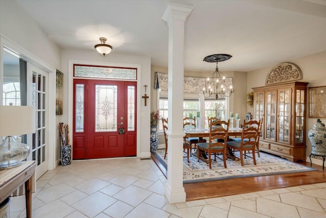 tiled foyer with a chandelier and ornate columns