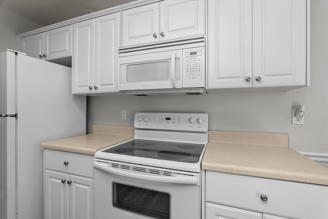 kitchen with white appliances, light countertops, and white cabinets