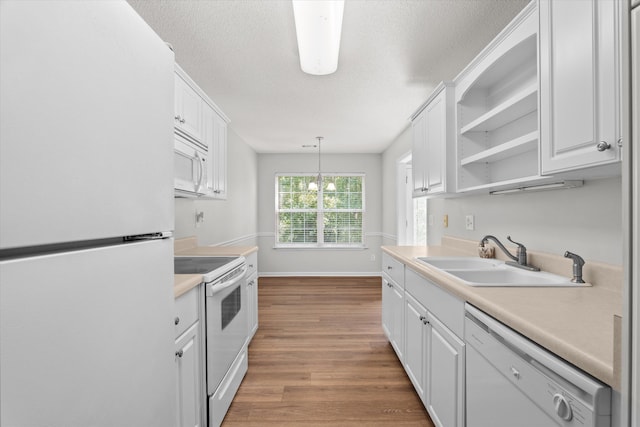 kitchen with white cabinets, a sink, and white appliances