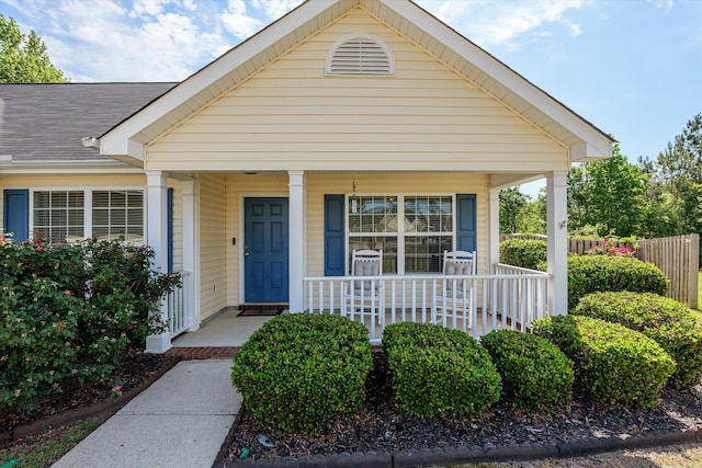 view of front of house featuring a porch and fence