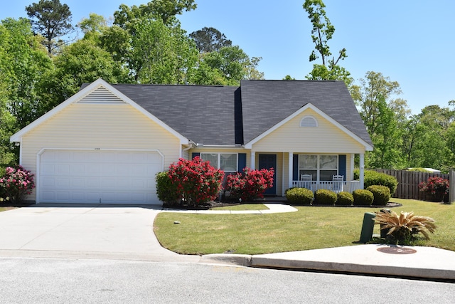 view of front of home featuring driveway, fence, an attached garage, a front yard, and a porch