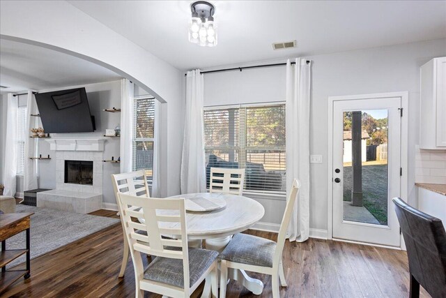 dining area with a fireplace and dark hardwood / wood-style flooring