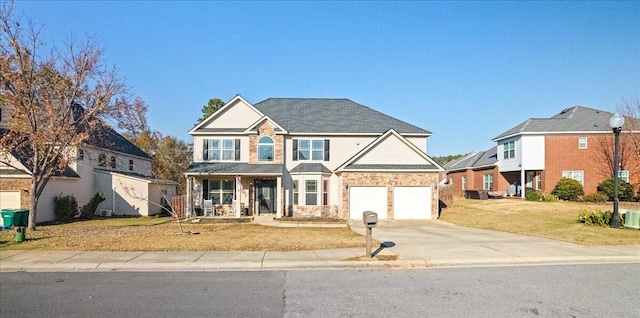 view of front of house featuring a porch, a garage, and a front yard