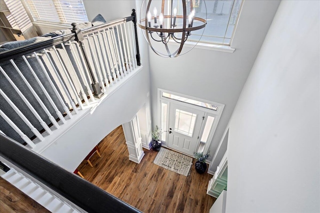 foyer entrance featuring a high ceiling, dark hardwood / wood-style flooring, and an inviting chandelier