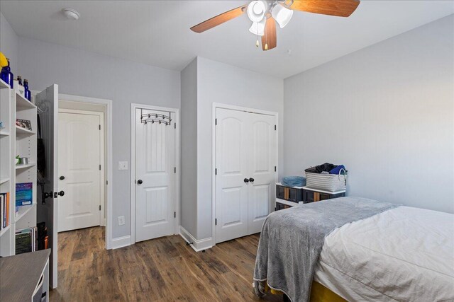 bedroom with dark hardwood / wood-style flooring and ceiling fan