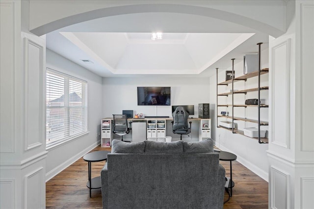 living room with dark wood-type flooring and a tray ceiling