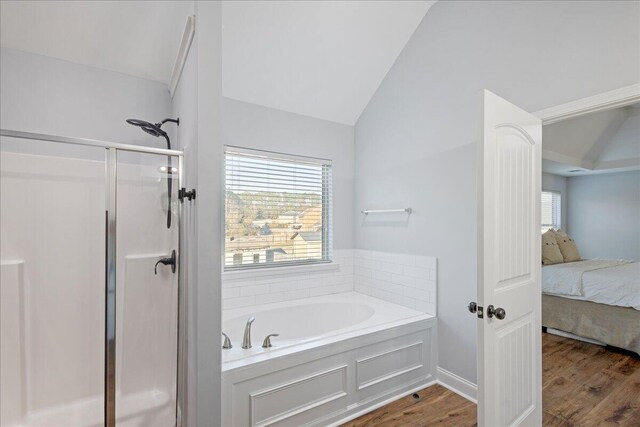 bathroom with wood-type flooring, shower with separate bathtub, and vaulted ceiling