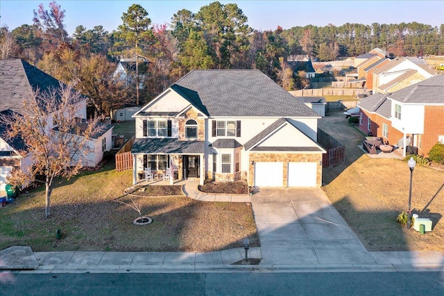 view of front of home featuring a porch, a garage, and a front yard