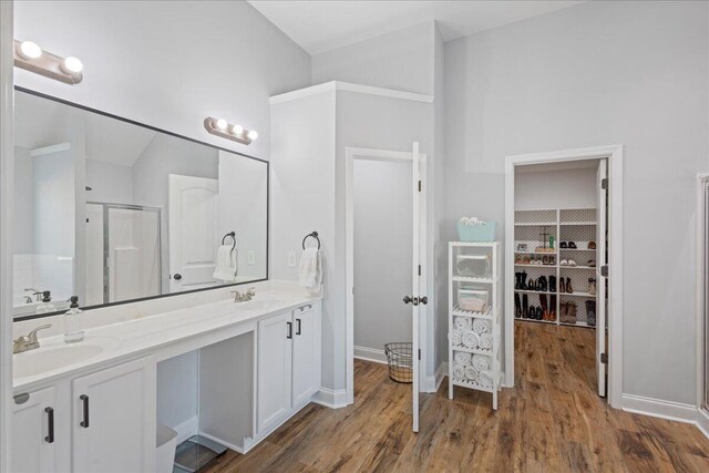 bathroom with hardwood / wood-style floors, vanity, and walk in shower