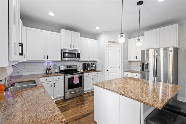 kitchen with tasteful backsplash, white cabinetry, sink, and stainless steel appliances