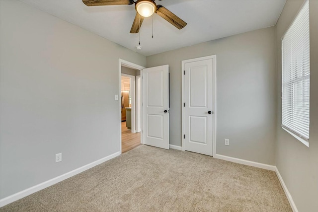 unfurnished bedroom featuring light carpet and ceiling fan