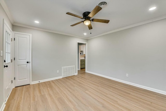 spare room featuring crown molding, light hardwood / wood-style floors, and ceiling fan