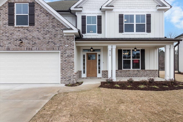 view of front of property with board and batten siding, concrete driveway, and brick siding