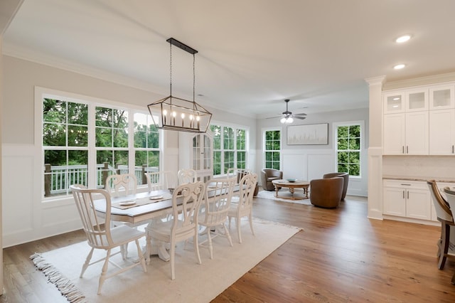 477 Rivernorth Dr, North Augusta, SC 29841 - dining area with a decorative wall, crown molding, light wood-style floors, ceiling fan, and a wainscoted wall
