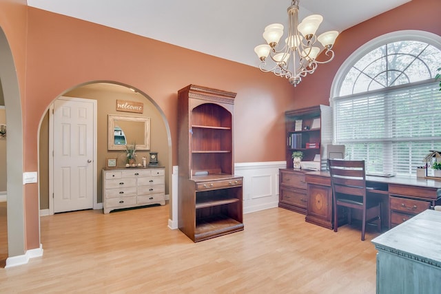 office area featuring built in shelves, light wood-type flooring, and a chandelier