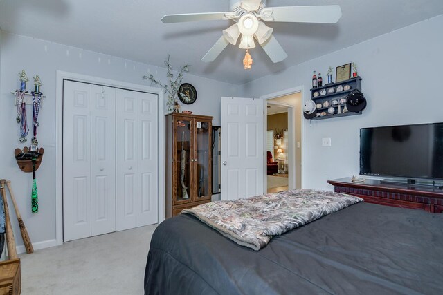 carpeted bedroom with ceiling fan and a closet