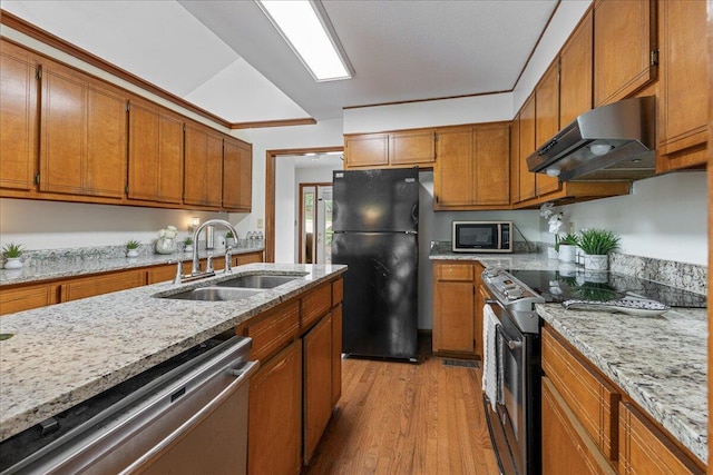 3736 Winchester Trl, Martinez, GA 30907 - kitchen featuring under cabinet range hood, appliances with stainless steel finishes, brown cabinetry, and light wood-style floors