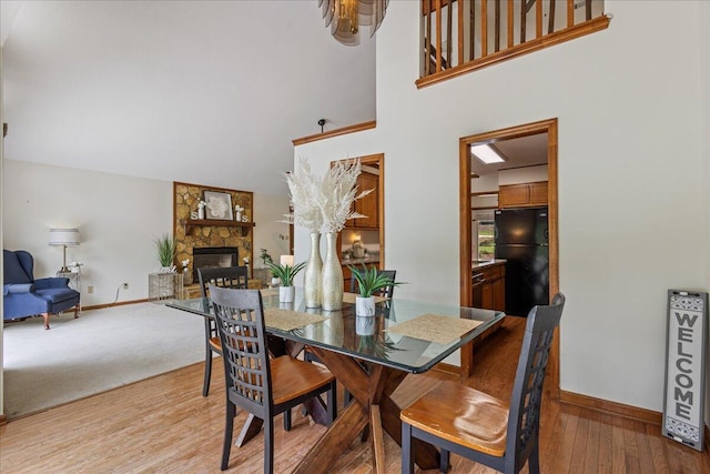 3736 Winchester Trl, Martinez, GA 30907 - dining space featuring wood finished floors, a stone fireplace, and a towering ceiling