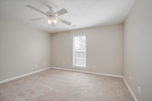 empty room featuring light colored carpet and ceiling fan